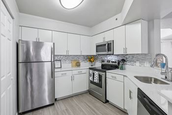 a kitchen with white cabinets and stainless steel appliances at Pembroke Pines Landings, Pembroke Pines, FL 33025